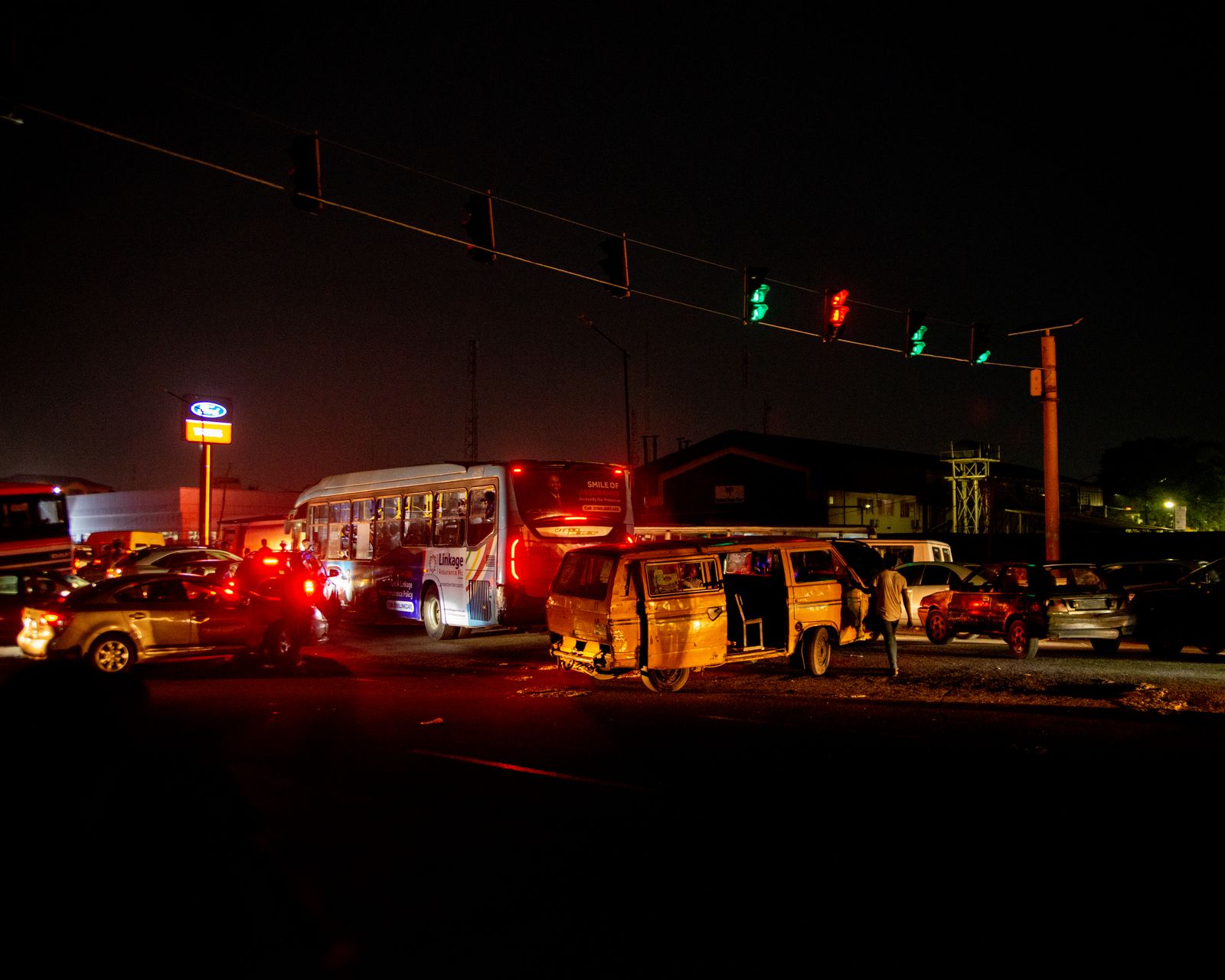 Damaged cars stopped on a city street at night after a collision with emergency lights reflecting off the road