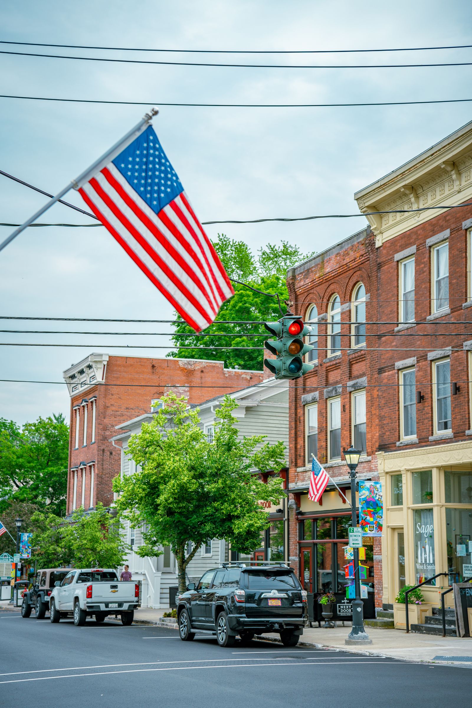 Older main street lined with low brick storefronts and angled curbside parking