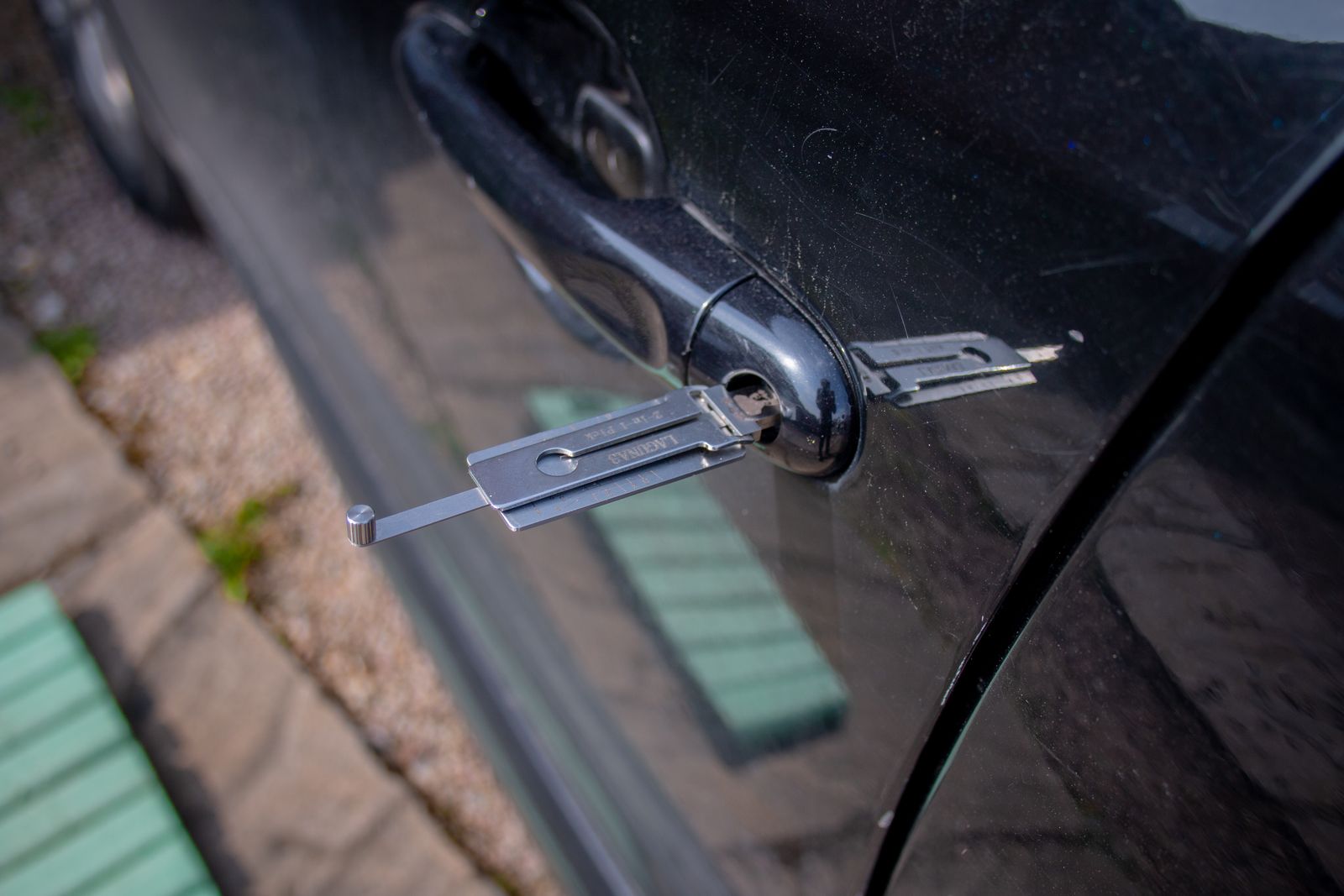 Long reach lockout tool fed through a car door to unlock it without breaking the window