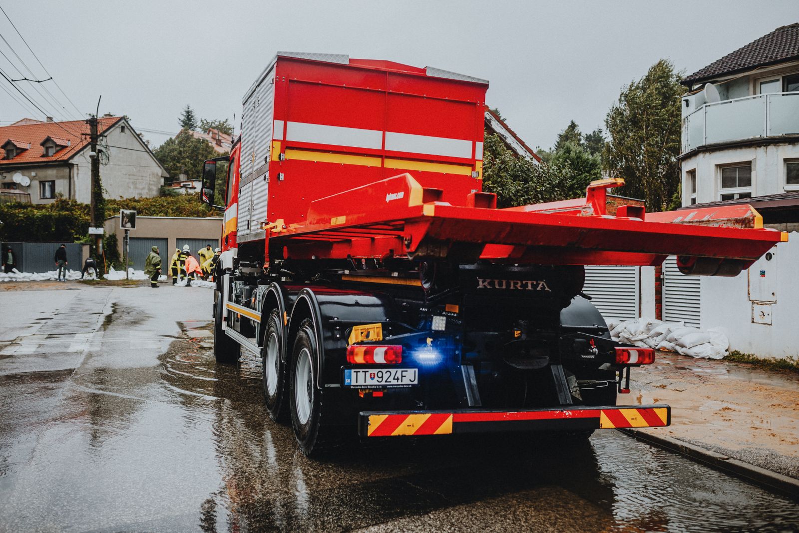 Tow truck working a wet street at night with its amber beacons lit during an emergency call