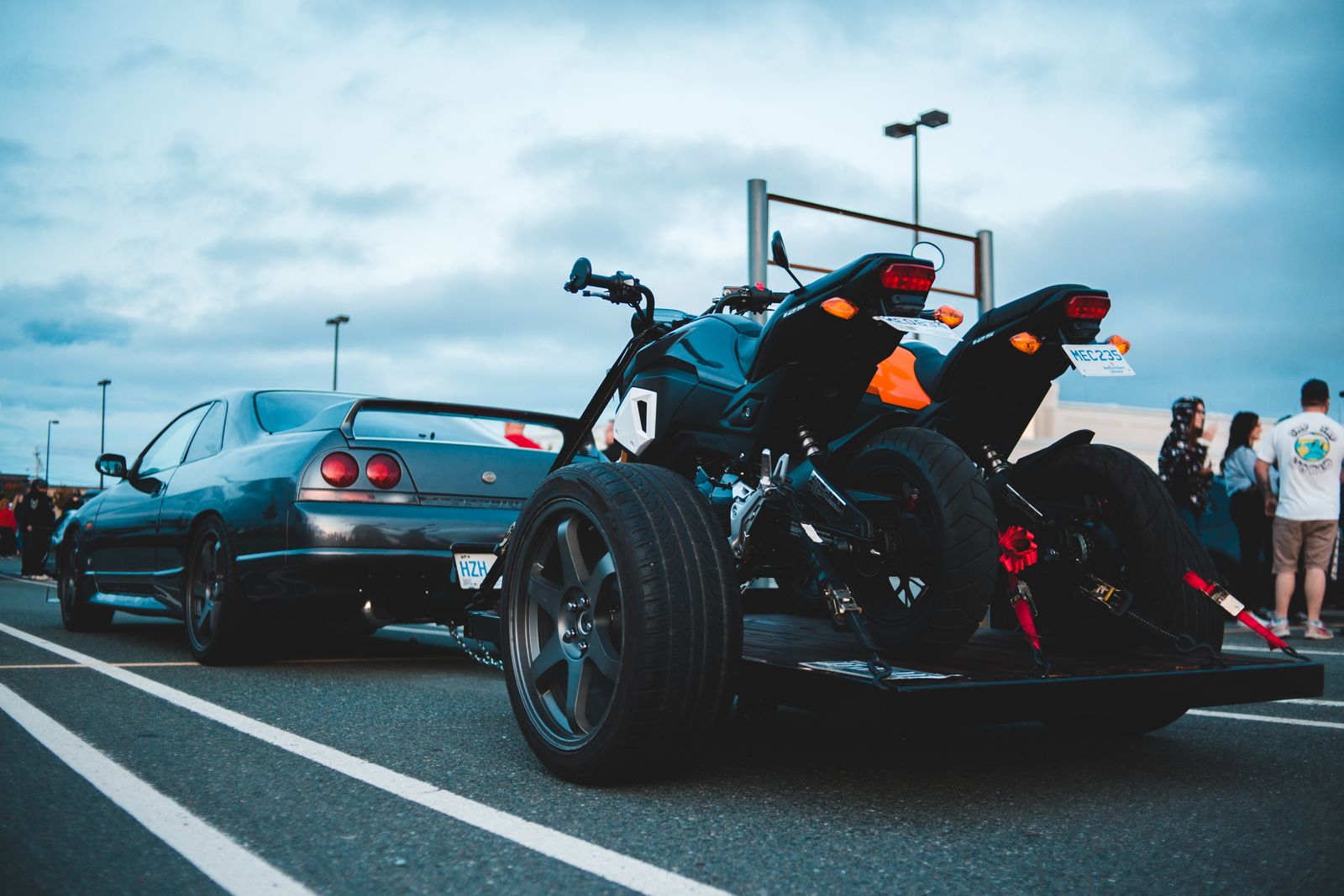 Motorcycles strapped upright on a towed transport trailer for motorcycle towing