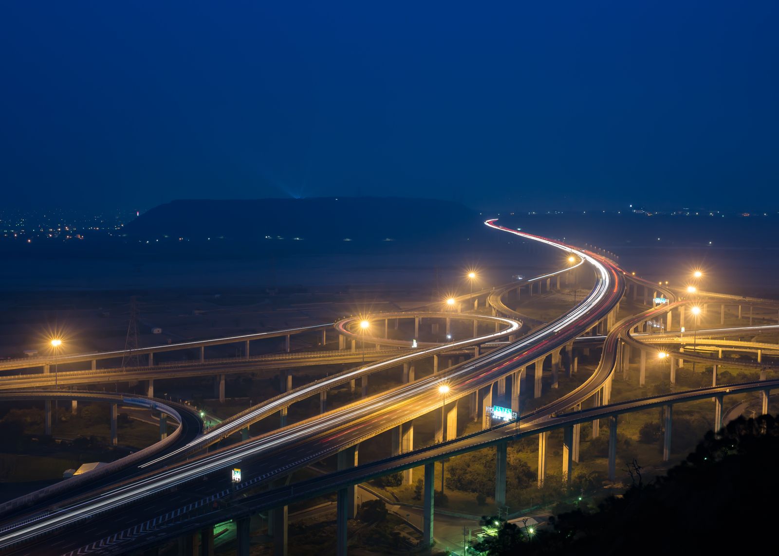 Highway interchange lit at night with ramps curving away in several directions